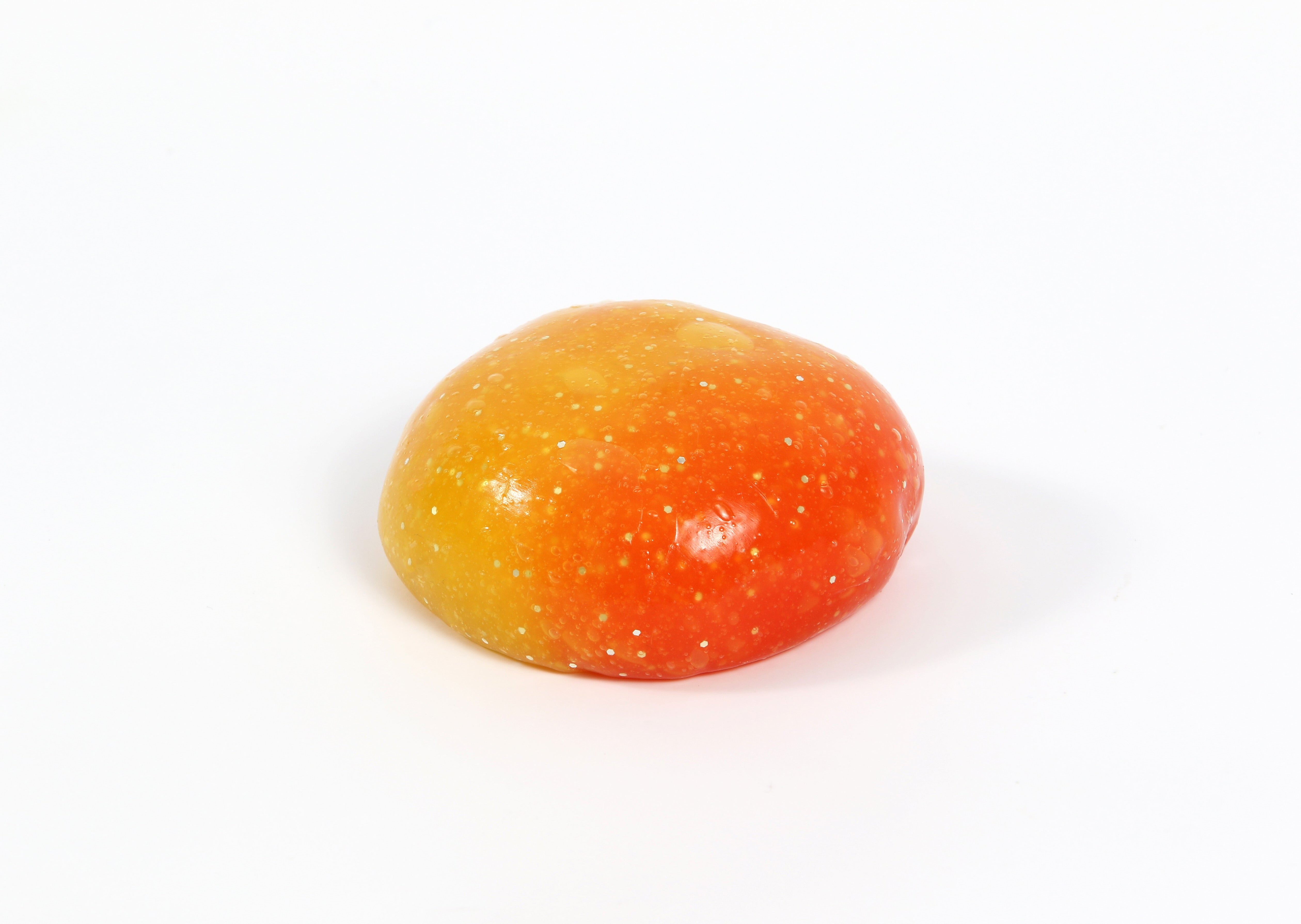 A ball of Messy Play Kit's color-changing Sunset slime with thermochromic pigment that changes from orange to yellow based on temperature.