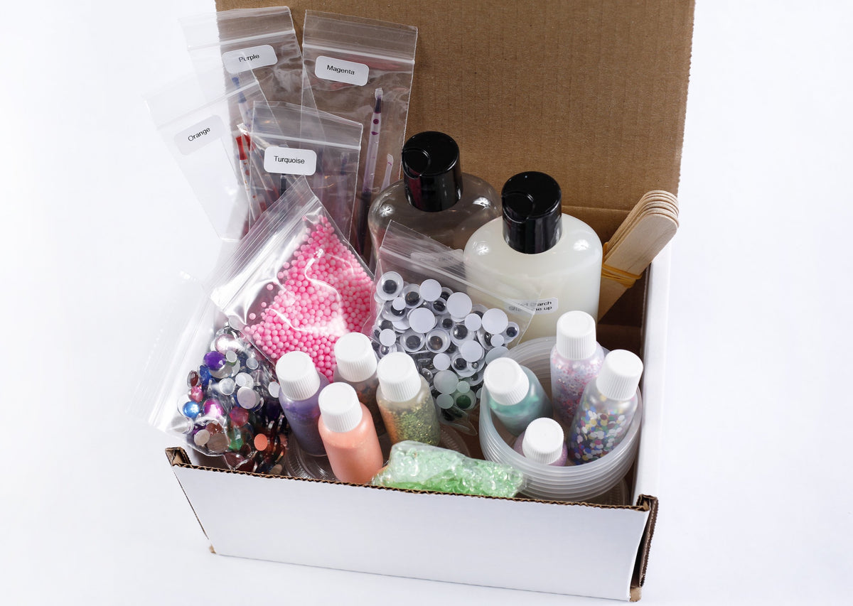 Box of slime making supplies including bottles of glue, liquid starch, pipettes of colors, mixing containers, stir sticks. Plus extra mix-ins like glitter, jewels, and googly eyes.