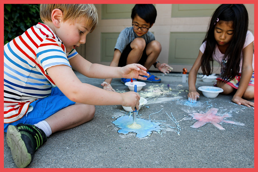 Kids doing 4th of July activities on the sidewalk