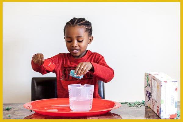 child measuring while playing with messy play kit - messy play teaches preschool math concepts