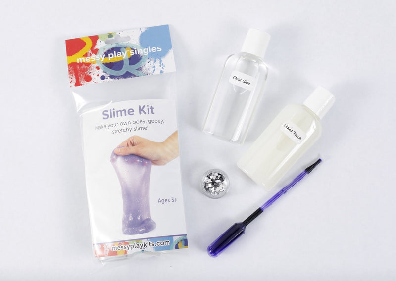 Packaging and contents of a purple glitter slime kit, including a glue bottle, liquid starch bottle, glitter, and a pipette of color.