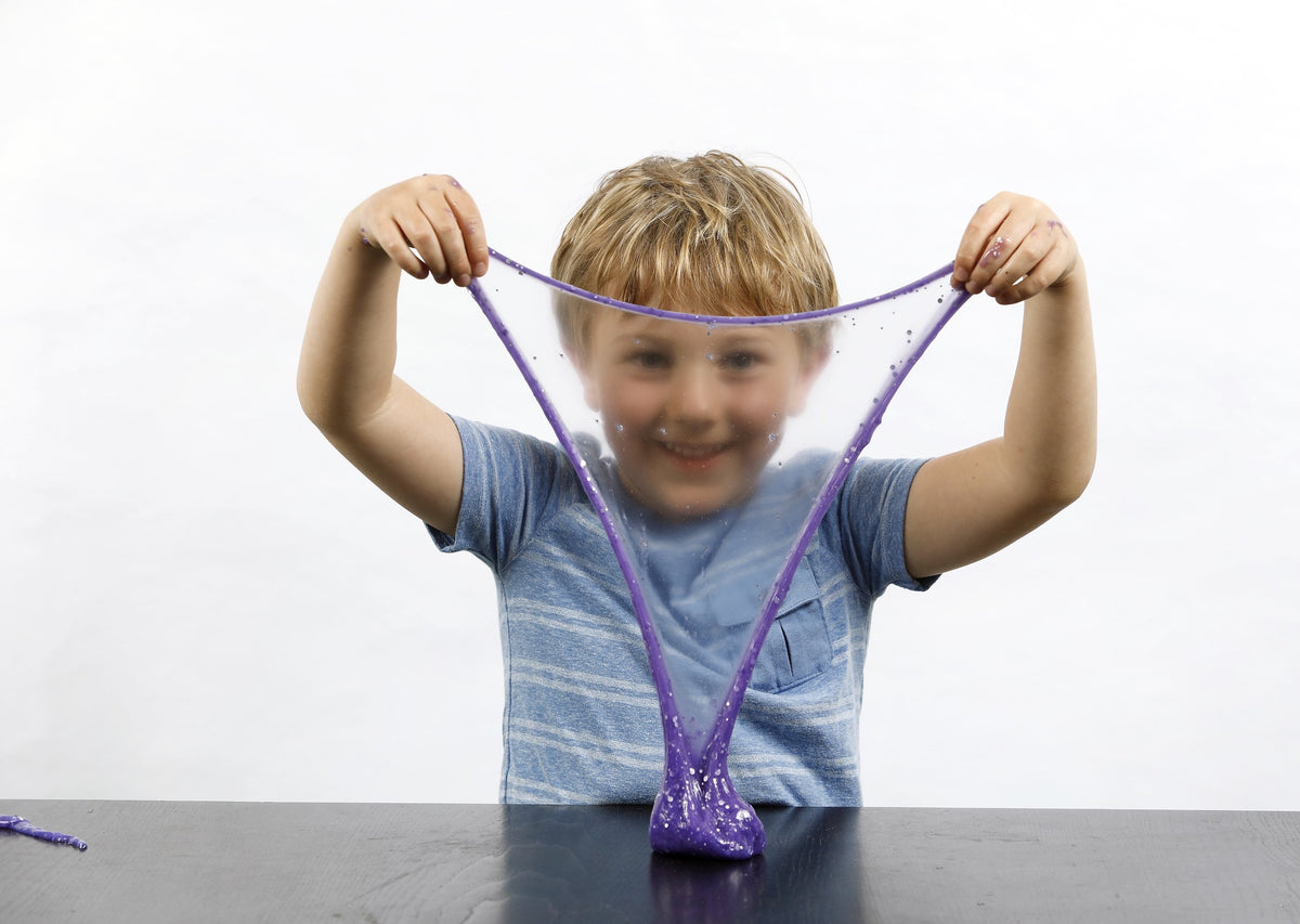 Young boy stretching purple Rockstar slime in front of his face.