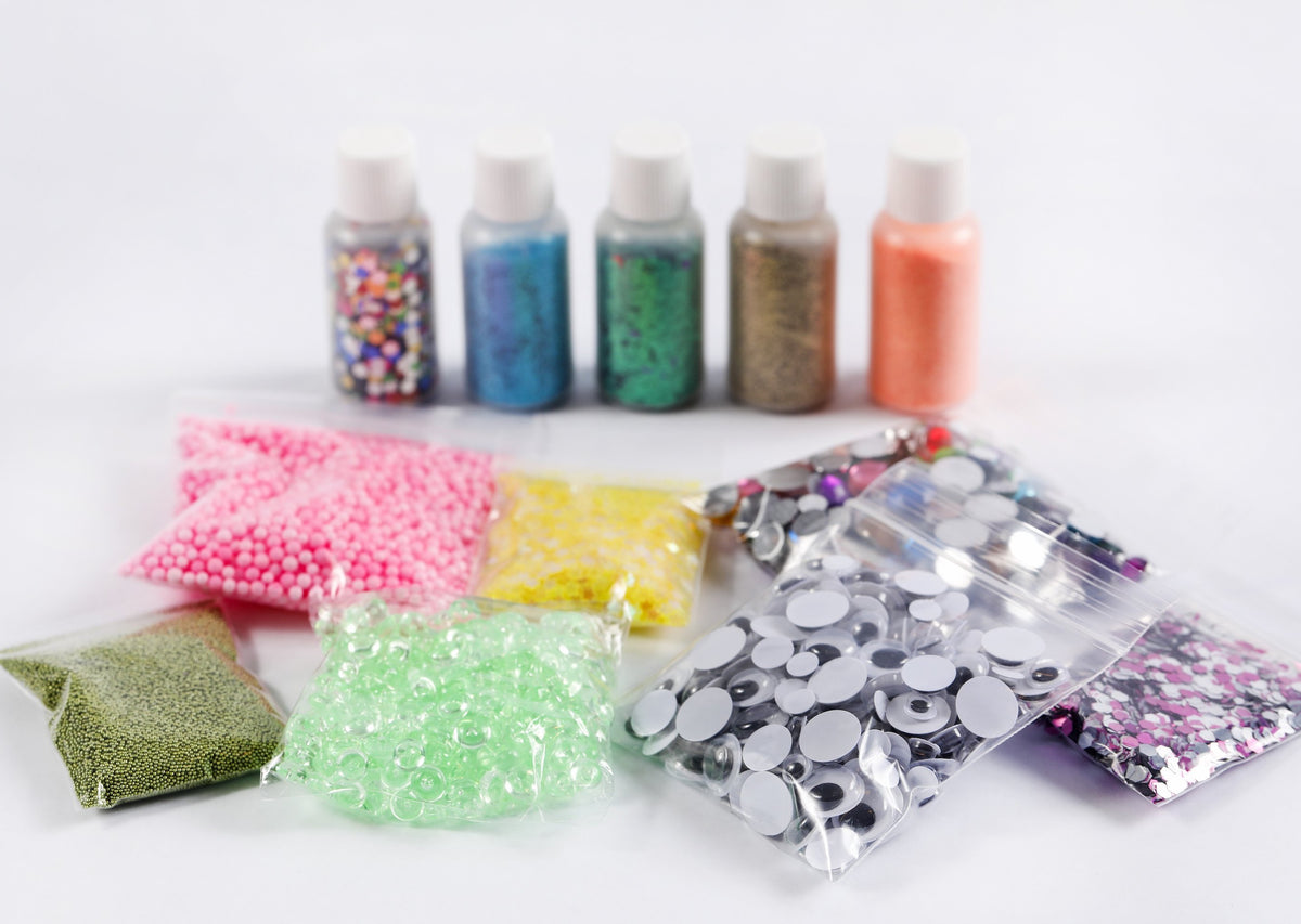 Mix-ins for slime making including beads, glitter, google eyes, jewels, and sequins.