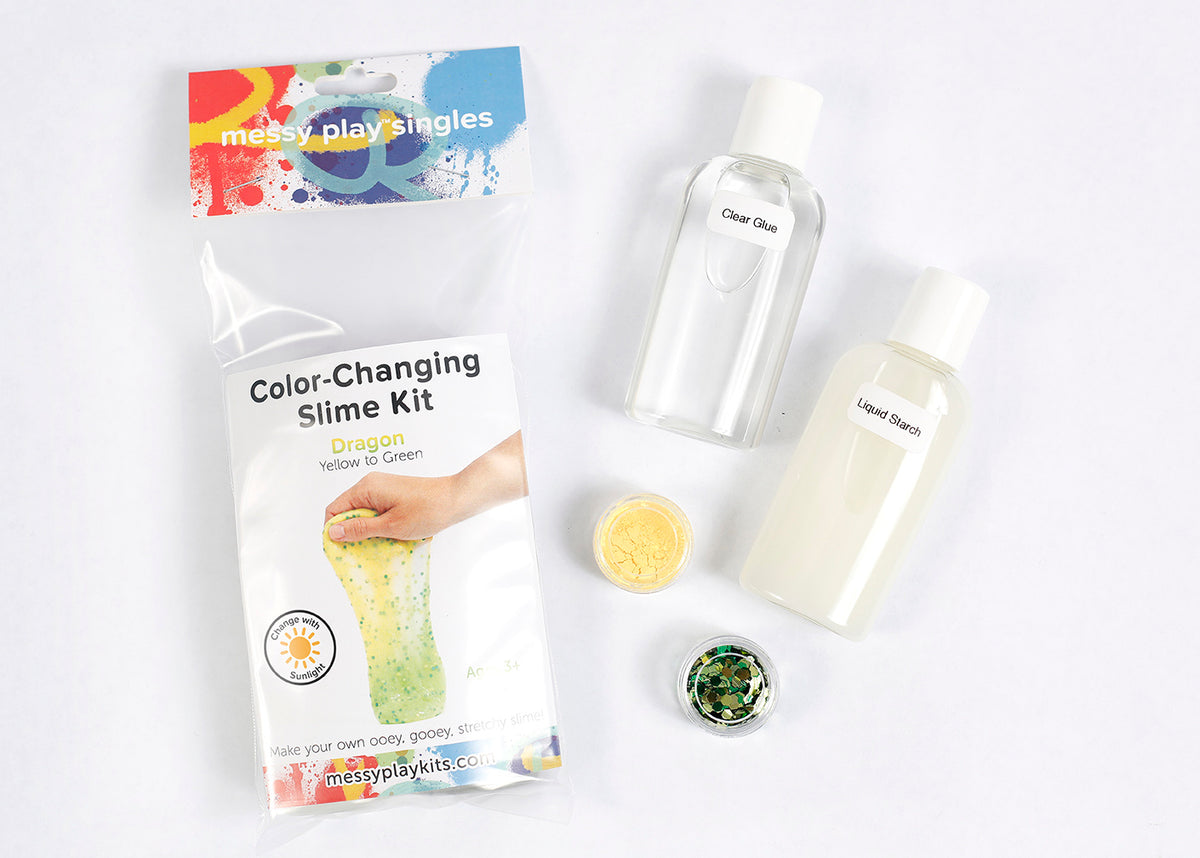 Packaging and contents of a Dragon slime kit, including a glue bottle, liquid starch bottle, glitter, and color-changing pigment that changes the slime from yellow to green in the sunlight