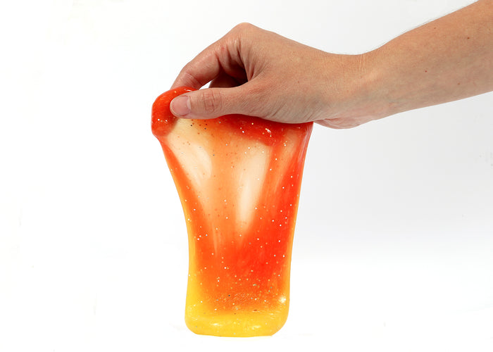 Hand holding Messy Play Kit's color-changing Sunset slime with thermochromic pigment that changes from orange to yellow based on temperature.