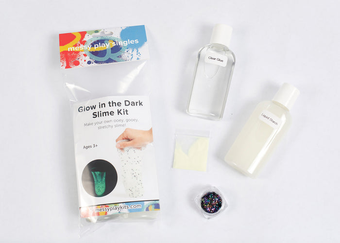Packaging and contents of a Glow in the Dark slime kit, including a glue bottle, liquid starch bottle, glitter, and glow in the dark powder packet.