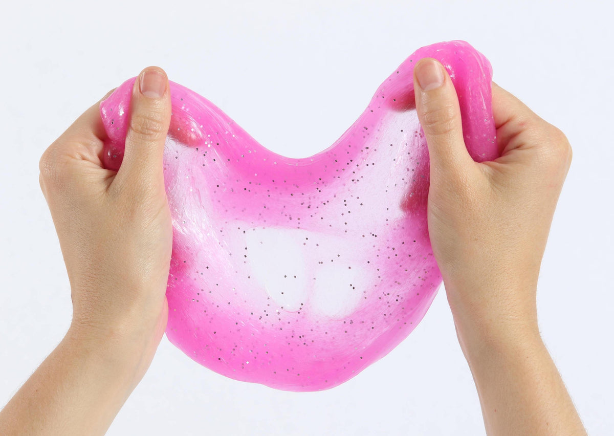 Two hands pulling and stretching the magenta glitter slime by Messy Play Kits.