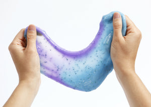Two hands stretching Messy Play Kit's color-changing Mermaid slime that changes from blue to purple in the sunlight