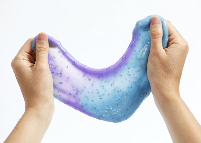 Two hands stretching Messy Play Kit's color-changing Mermaid slime that changes from blue to purple in the sunlight