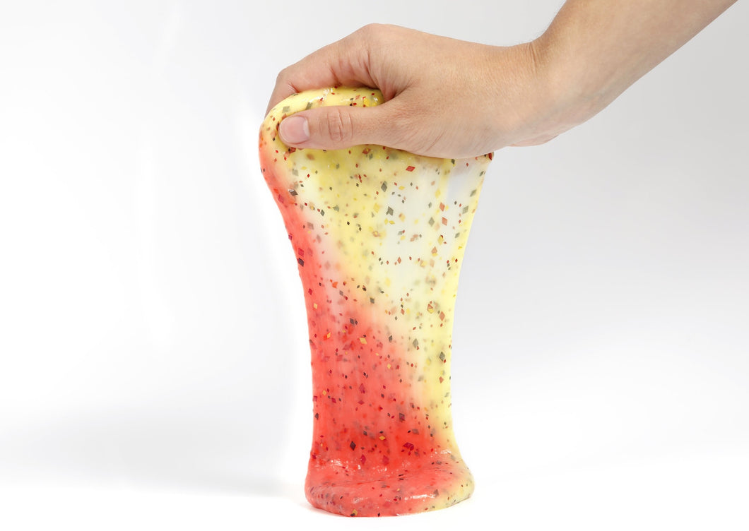 Hand holding Phoenix slime that changes from yellow to red in the sunlight